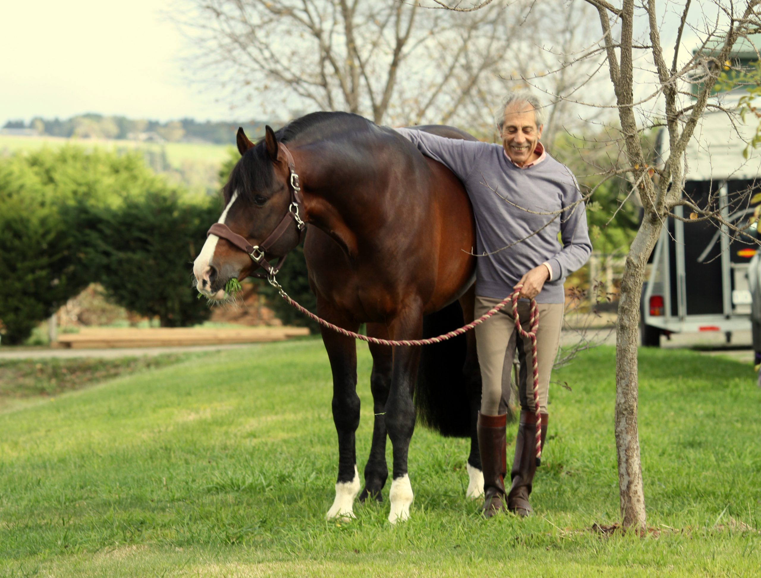Manolo Mendez relaxing while his horse eats grass